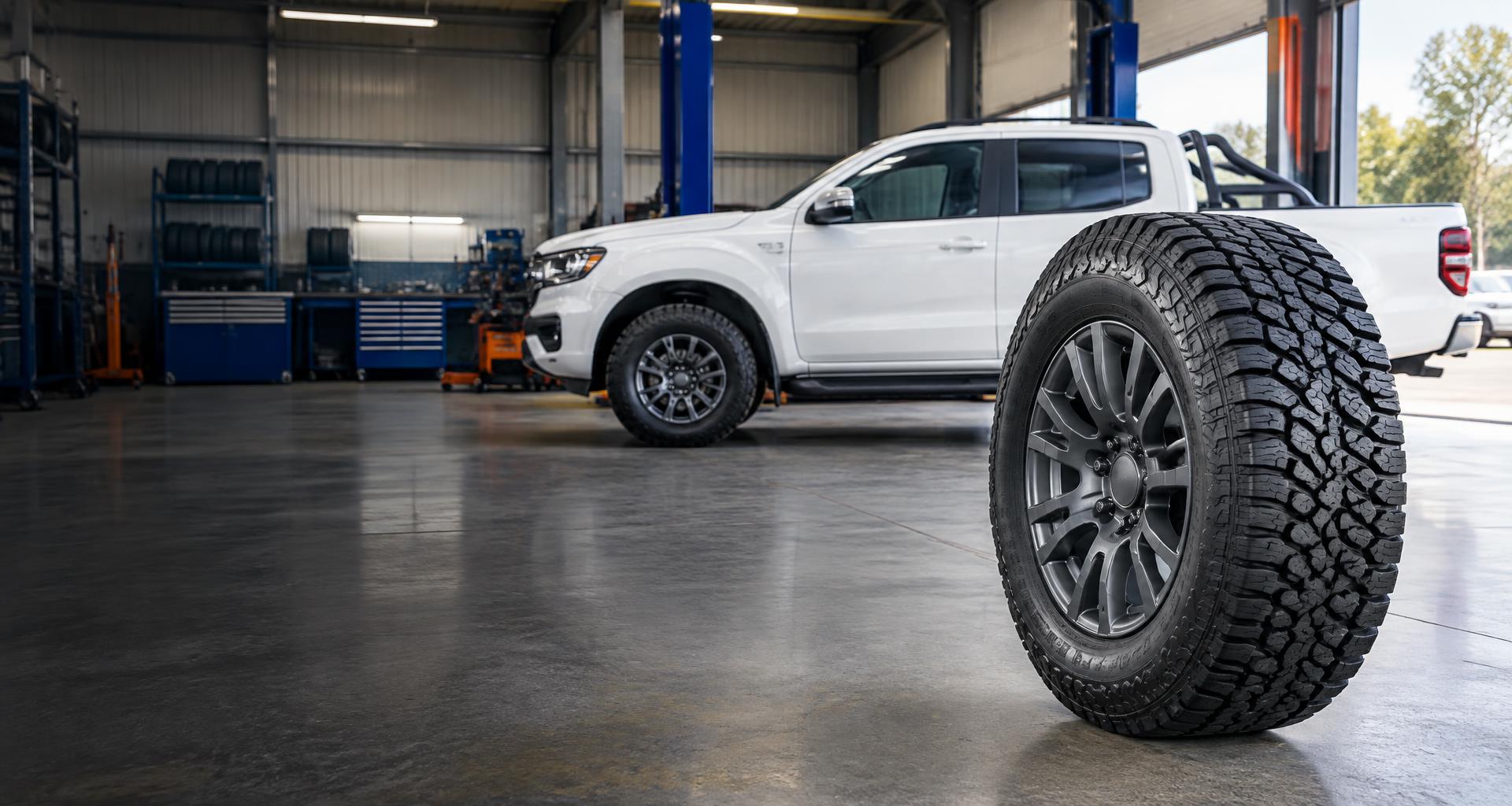 Illustrative all-terrain tyre and utility vehicle in a tyre workshop